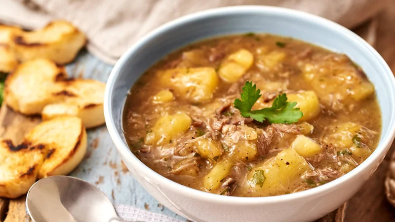 Sopa de mandioca com carne seca na panela de ceramica